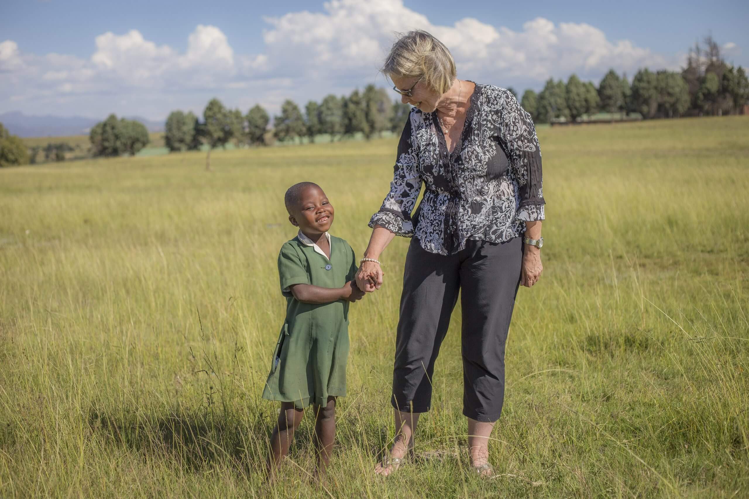 Peg Herbert standing with school girl in a field