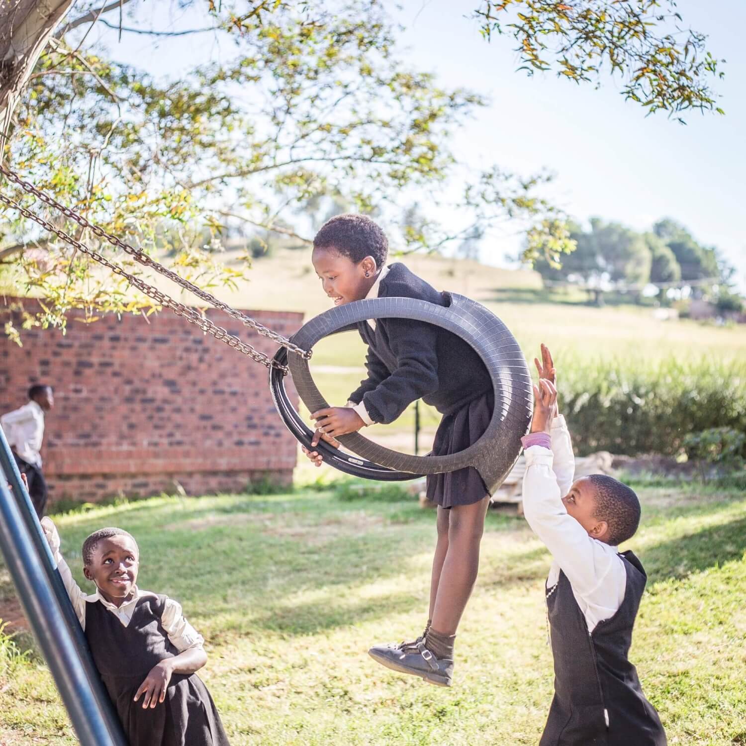 grandmother standing with children in a lesotho landscape